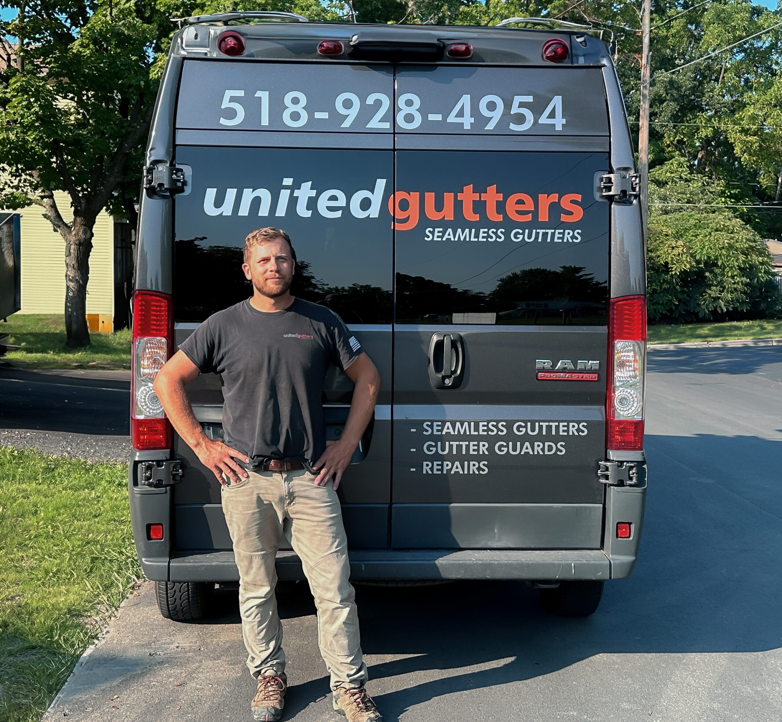 Oleg, owner of United Gutters, standing in front of the company's branded service van